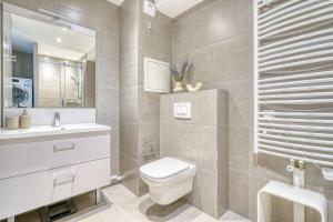 a bathroom with a toilet and a sink and a mirror at Appartement de luxe - Aux portes de Paris in Saint-Mandé +13 photos