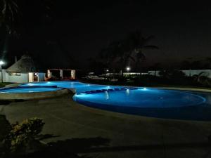 a large pool with blue water at night at Depto. frente al mar con Club de Playa in Acapulco