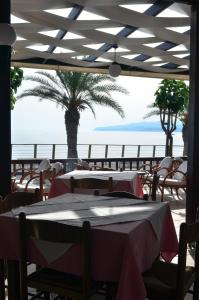 a restaurant with tables and a view of the ocean at Hotel Thisvi in Stalís