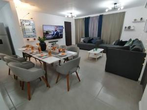 a living room with a table and chairs and a couch at Depto. frente al mar con Club de Playa in Acapulco