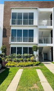 a large white building with a garden in front of it at Depto. frente al mar con Club de Playa in Acapulco