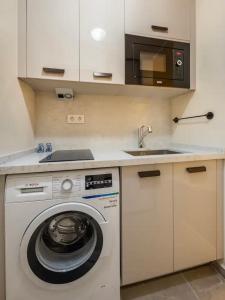 eine Küche mit einer Waschmaschine und einem Waschbecken in der Unterkunft Osmanbey’de geniş stüdyo daire in Istanbul