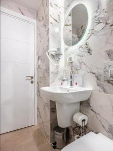 ein weißes Badezimmer mit einem Waschbecken und einem Spiegel in der Unterkunft Osmanbey’de geniş stüdyo daire in Istanbul
