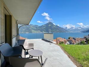 a patio with chairs and a table and a view of the water at Chez-Marie Vue fantastique entre lac et montagne in Beckenried
