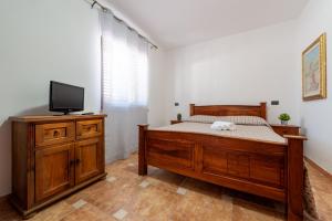 a bedroom with a bed and a flat screen tv at Residence Martino - Casa Vacanze in Castelnuovo Cilento