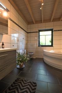 La salle de bains est pourvue d'une baignoire, de toilettes et d'un lavabo. dans l'établissement 4 Sterne Ferienwohnung Rabenlay, à Oberneisen