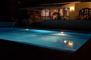 a swimming pool lit up at night at Hotel Thisvi in Stalís