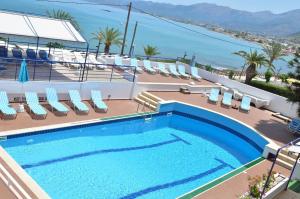 a swimming pool with chairs and a view of the ocean at Hotel Thisvi in Stalís
