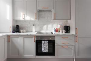 a white kitchen with white cabinets and an oven at Townhouse in Belfast in Belfast