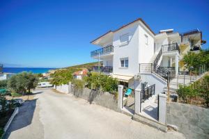 a white house on a hill with a road at Thomas Apartments in Skala Marion
