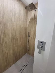ein Bad mit einer Dusche und einer Holzwand in der Unterkunft O 3 de Monteferro in Nigrán