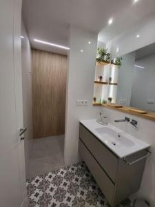 ein Bad mit einem Waschbecken und einem Spiegel in der Unterkunft O 3 de Monteferro in Nigrán