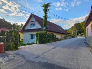 an empty street with a house with ivy at Apartmán Tajov pre 5-6 osôb, privatne parkovanie a terasa in Tajov