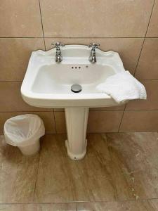 lavabo blanco en el baño con cubo de basura en Castle View Suite, en Sligo