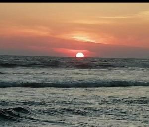 a sunset over the ocean with the sun in the horizon at EXCELENTE Depa en Acapulco Diamante FRENTE AL MAR! in Acapulco