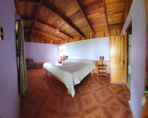 a bedroom with a large bed and a wooden ceiling at Sunset Monteverde in Monteverde Costa Rica
