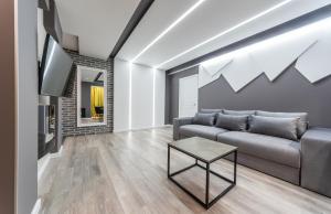 a living room with a couch and a table at Luxrent Apartments on Lesi Ukrainki - Kiev in Kyiv