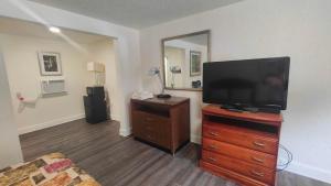 a living room with a flat screen tv on a dresser at Mount Airy Motel in Mount Airy