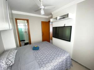um quarto com uma cama e uma televisão de ecrã plano em 3 Quartos vila velha Praia de Itaparica em Vila Velha