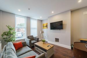 a living room with a couch and a tv on a wall at Augusta House - Moseley in Birmingham