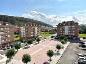 uma vista para um parque de estacionamento com edifícios e árvores em La Piragua em Ribadesella