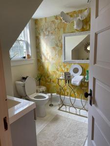 a bathroom with a toilet and a sink and a mirror at Das Gasthaus, The Inn of Claysburg in Claysburg