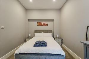 a bedroom with a bed with two blue towels on it at Augusta House - Moseley in Birmingham