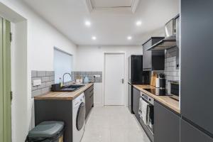 a kitchen with a sink and a dishwasher at Augusta House - Moseley in Birmingham