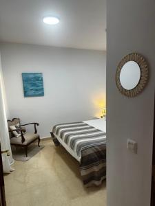 a bedroom with a bed and a mirror and a chair at Aventura en Buenavista del Norte in Buenavista del Norte