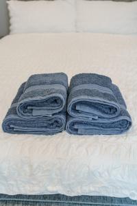 three towels are stacked on top of a bed at Augusta House - Moseley in Birmingham +7 photos