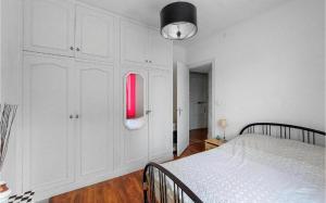 a white bedroom with a bed and a red light at appartement t3 terrasse in Troyes