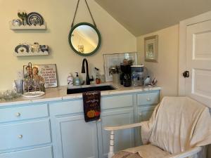 a kitchen with a counter with a mirror and a chair at Das Gasthaus, The Inn of Claysburg in Claysburg