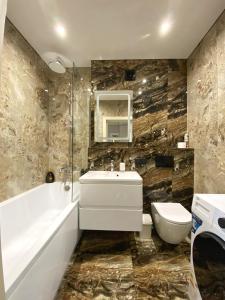łazienka z wanną, umywalką i toaletą w obiekcie Apatrment in Khmelnytsky street Natasha w Lwowie