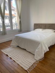 a bedroom with a white bed with a large window at Appart hyper-centre, à 5 min à pieds de la gare in Longwy