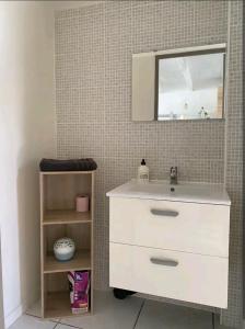 a bathroom with a white sink and a mirror at Maisonnette au calme avec parking in Marguerittes