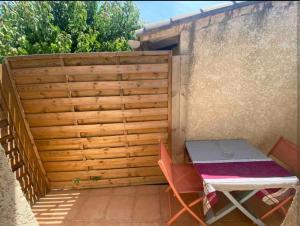 a small patio with a table and a fence at Maisonnette au calme avec parking in Marguerittes