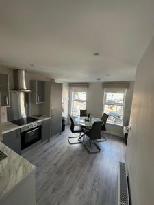 a kitchen and living room with a table and chairs at Westland Suites - Stylish, Modern, Elegant, Central Apartments A in Derry Londonderry