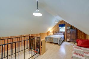 un dormitorio en el ático con una cama y una escalera en Riverfront Briceville Cabin with Patio and Fire Pit!, en Briceville