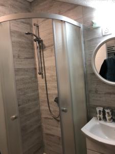 La salle de bains est pourvue d'une douche et d'un lavabo. dans l'établissement Apartmani Kaić, à Livno