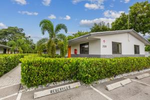 una casa con una siepe davanti di Harbourside Flats a Fort Lauderdale