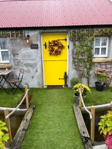 a yellow door on a house with a yard at The Nest Quaint Luxury Cottage Getaway in Tiragarvan