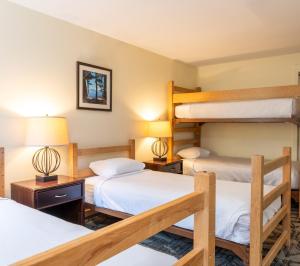 a bedroom with two bunk beds and two lamps at Grand Summit Hotel at Attitash in Bartlett