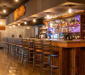 a bar with a row of bar stools at Grand Summit Hotel at Attitash in Bartlett