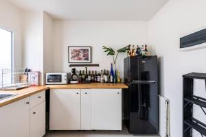 a kitchen with white cabinets and a black refrigerator at 55th AREA in Nonthaburi