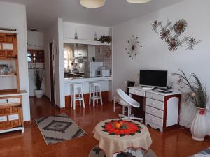 ein Wohnzimmer mit einem Schreibtisch und einer Küche in der Unterkunft MI CASITA DE LA PLAYA in Puerto del Carmen