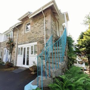 a stone house with a blue staircase in front of it at Peaceful and Stunning Waterside Location in Helensburgh