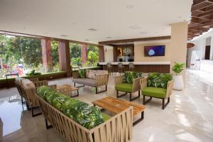 a lobby with couches and chairs and a table at Hotel Kualamaná Cafam Melgar in Melgar