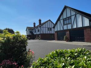 ein Haus mit schwarzen und weißen Fenstern und einer Auffahrt in der Unterkunft Greenfields Country House in Latton