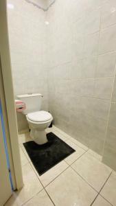 La salle de bains est pourvue de toilettes et d'un tapis noir. dans l'établissement Appart hyper-centre, à 5 min à pieds de la gare, à Longwy