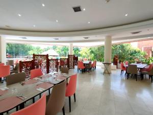 a restaurant with tables and chairs and a large window at Hotel Kualamaná Cafam Melgar in Melgar